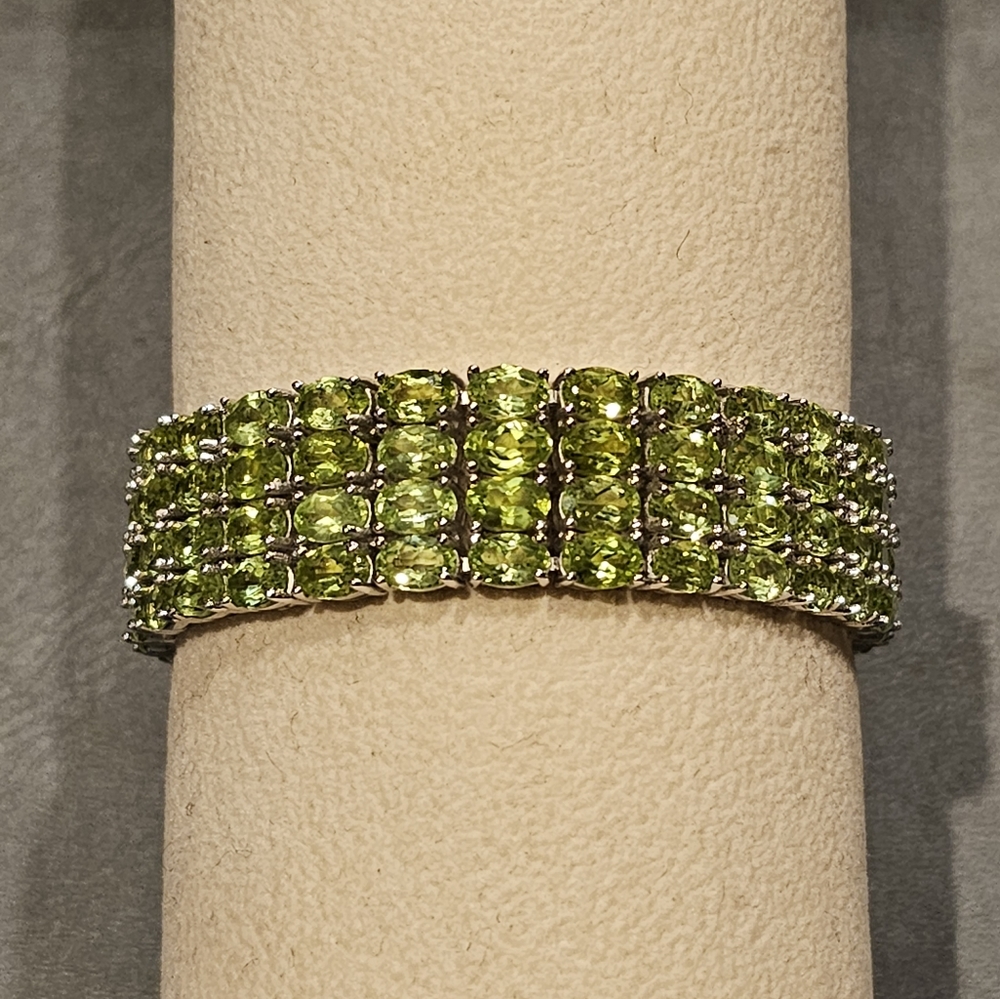 Natural Peridot 4-row tennis bracelet set in rhodium plated sterling silver.